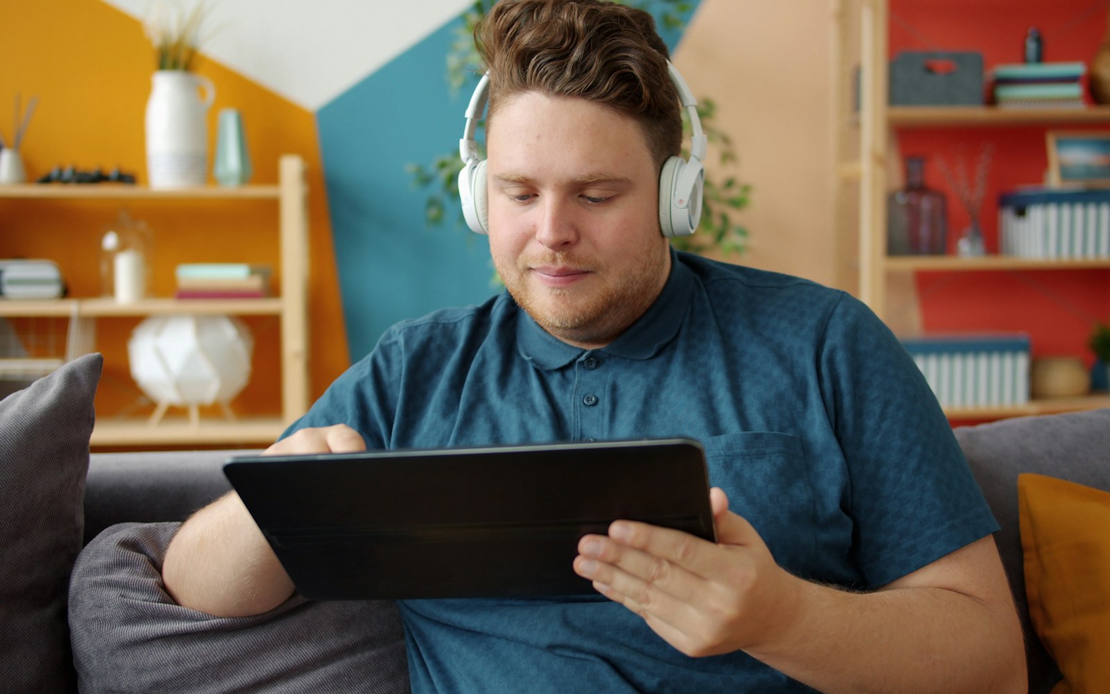 Person enjoying movies and music on a tablet with wireless headphones